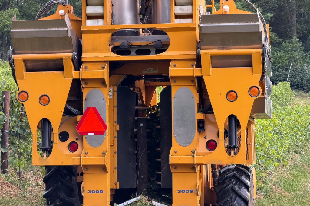 A close up shot of the inner workings of a harvester, where you can see the soft rods that jostle the grape clusters free