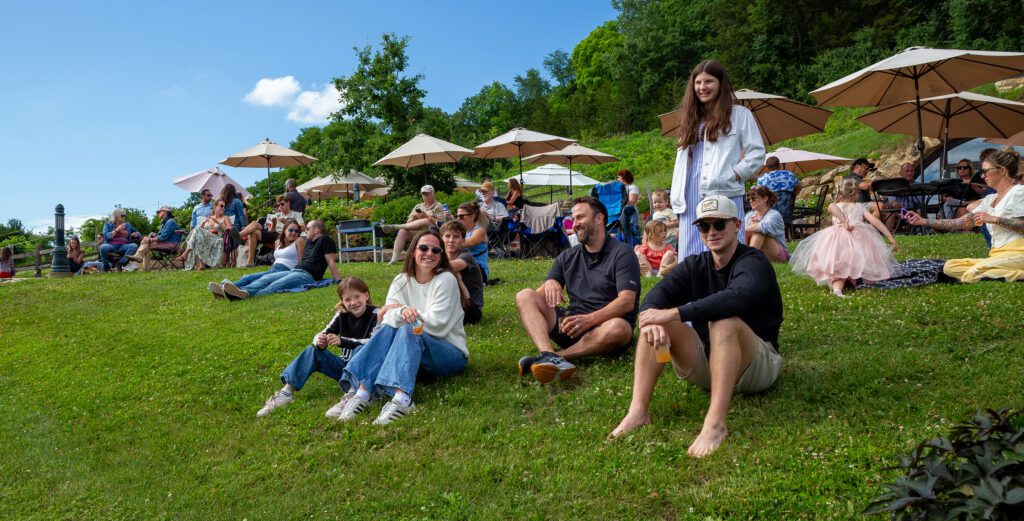 Many people and families enjoying the weather and music on the hillside at Wollersheim Summer Serenade.